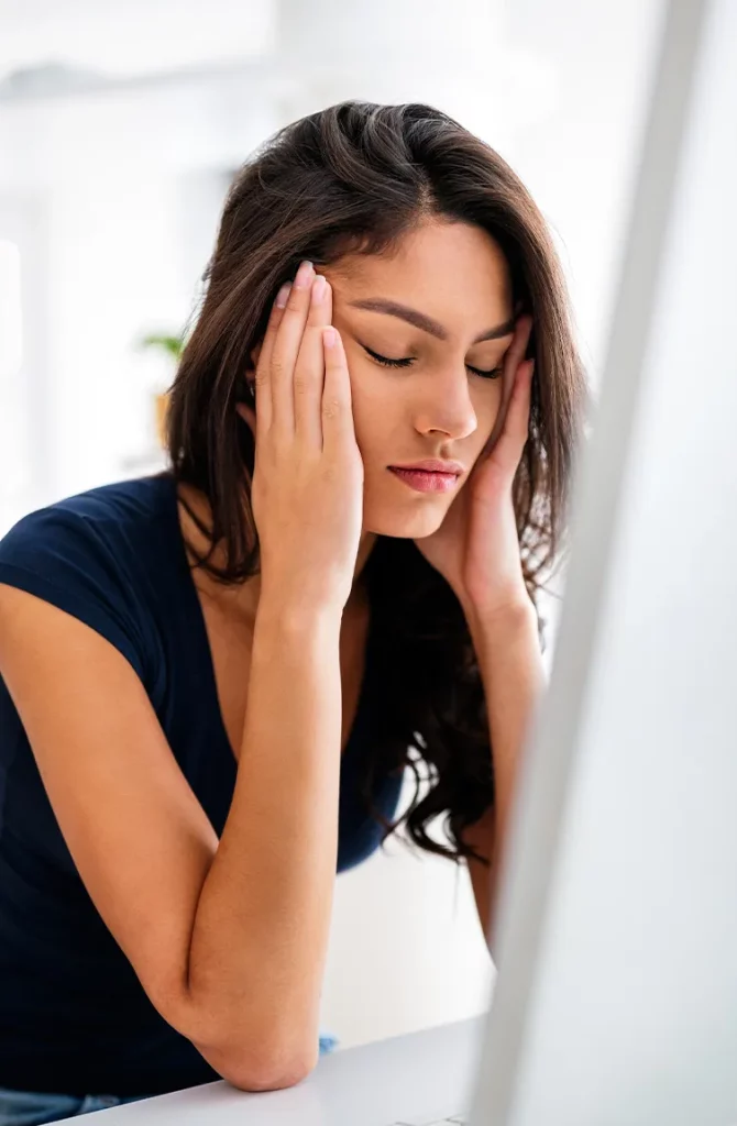 Woman holding head in hands with a headache