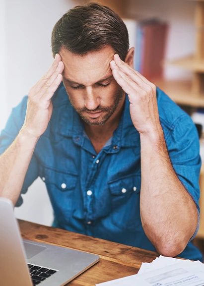man holding head in hands from head and neck pain.